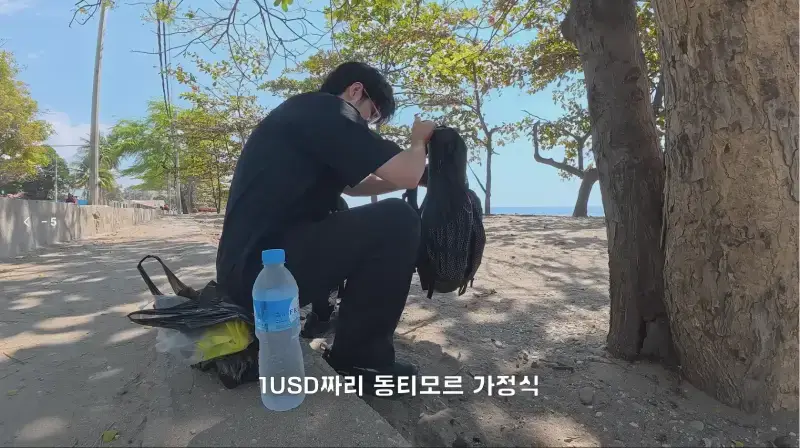동티모르 길거리에서 밥 먹다가 애들한테 둘러싸인 남자의 내용을 보여주는 이미지